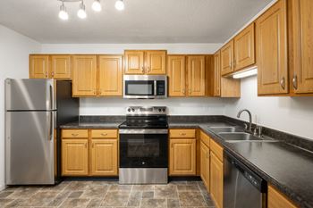 a kitchen with wooden cabinets and stainless steel appliances